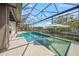 Lakeside pool featuring spa, sun umbrella, and a screened enclosure offering privacy and waterfront enjoyment at 5569 Cape Leyte Dr, Sarasota, FL 34242