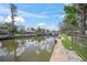 Picturesque waterfront view with lush landscaping and clear skies reflecting in the tranquil canal at 5569 Cape Leyte Dr, Sarasota, FL 34242