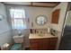 This bathroom features a vanity with wood cabinets, oval mirror, toilet and decorative tile backsplash at 620 Camellia Ave, Ellenton, FL 34222