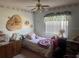 This bedroom features a ceiling fan, a twin bed with decorative pillows, and floral wallpaper border at 620 Camellia Ave, Ellenton, FL 34222