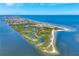 Aerial shot of a coastal neighborhood with waterfront homes, boats, and natural greenery on a beautiful sunny day at 6219 Golden Nettle Dr, Apollo Beach, FL 33572
