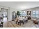 Formal dining room offers a glass table with seating for six, lots of natural light, and hardwood flooring at 6219 Golden Nettle Dr, Apollo Beach, FL 33572