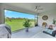 Screened lanai with a ceiling fan and furniture, offering a view of the landscaped backyard at 6219 Golden Nettle Dr, Apollo Beach, FL 33572
