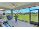 Covered lanai with ceiling fan, grill, and seating area, providing a relaxing outdoor space overlooking the yard at 6219 Golden Nettle Dr, Apollo Beach, FL 33572