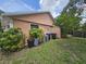 View of the home's exterior and backyard, featuring landscaping and trash receptacles at 6305 Bikini Rd, Sarasota, FL 34241