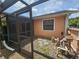 View of the backyard and exterior with a screened in enclosure for utilities at 6305 Bikini Rd, Sarasota, FL 34241