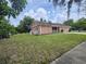 Side view of home with a lush lawn, white picket fence, and mature trees at 6305 Bikini Rd, Sarasota, FL 34241