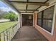 Covered front porch with sliding glass door and neutral concrete flooring at 6305 Bikini Rd, Sarasota, FL 34241