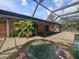 Backyard featuring a hot tub and covered seating area under a screened lanai at 6305 Bikini Rd, Sarasota, FL 34241