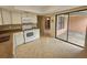 Open kitchen with white appliances and a sliding glass door to the patio at 6305 Bikini Rd, Sarasota, FL 34241