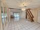 Open living room showcasing ceramic tile floors and a stairway to the loft space at 6305 Bikini Rd, Sarasota, FL 34241