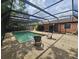 Relaxing pool area under a screened lanai, complete with seating and a view of lush landscaping at 6305 Bikini Rd, Sarasota, FL 34241