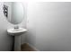 Bathroom with pedestal sink and round mirror at 6358 Fairmont Ln, Palmetto, FL 34221