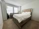 Bedroom with a bed with a light padded headboard, dresser, and ample natural light from the window at 6358 Fairmont Ln, Palmetto, FL 34221