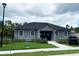 Gray clubhouse exterior with arched windows, well-kept lawn, and golf cart for community use at 6358 Fairmont Ln, Palmetto, FL 34221