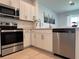 Bright kitchen with stainless steel appliances, white cabinets, and tile flooring at 6358 Fairmont Ln, Palmetto, FL 34221