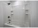Clean, tiled shower-tub featuring recessed shelves and clear shower curtain, ideal for a functional bathroom at 6358 Fairmont Ln, Palmetto, FL 34221