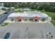 Aerial view of a community center building with palm trees, parking, an American flag, and a blue car at 6710 36 E Ave # 114, Palmetto, FL 34221