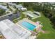 Aerial view of pool, shuffleboard courts, lounge chairs, palm trees, parking, and manufactured homes at 6710 36 E Ave # 114, Palmetto, FL 34221
