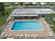 Community pool with brick patio, metal-roofed building, lounge chairs, and nearby manufactured homes in the background at 6710 36 E Ave # 114, Palmetto, FL 34221