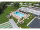 Overhead view of a community pool featuring a building with a metal roof, lounge chairs, and shuffleboard courts at 6710 36 E Ave # 114, Palmetto, FL 34221