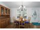 Cozy dining area with hardwood floors, chandelier, wood table with blue chairs, and a built-in china cabinet at 6710 36 E Ave # 114, Palmetto, FL 34221