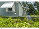 Exterior side view showing home accessibility via ramp, green bushes, green siding, and white awnings at 6710 36 E Ave # 114, Palmetto, FL 34221