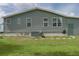 Exterior side view with green vinyl siding, and a well-maintained lawn in the backyard at 6710 36 E Ave # 114, Palmetto, FL 34221