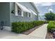 Exterior side view of home featuring awnings, green shrubs, mulch, a concrete sidewalk, and green siding at 6710 36 E Ave # 114, Palmetto, FL 34221