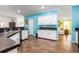 Bright kitchen featuring white cabinets, sleek countertops, wood floors, and a pass-through to the living room at 6710 36 E Ave # 114, Palmetto, FL 34221