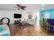 Open living room with hardwood floors, ceiling fan, white sofas, bar seating, and a modern entertainment center at 6710 36 E Ave # 114, Palmetto, FL 34221