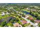Aerial view of a residential neighborhood with golf course, ponds, and mature trees at 7133 Dornough Ln, Bradenton, FL 34202