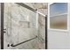 Modern bathroom with marble tile shower, glass door, and recessed niche at 7133 Dornough Ln, Bradenton, FL 34202