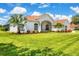 Beautiful single-story home with lush green lawn, mature trees, and colorful flowerbeds at 7133 Dornough Ln, Bradenton, FL 34202