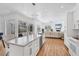 Spacious open kitchen boasts white cabinets, an island, stainless appliances, and seamlessly flows into living room at 7133 Dornough Ln, Bradenton, FL 34202