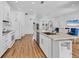 Open concept kitchen features white cabinets, stainless steel appliances, and a large island with seating at 7133 Dornough Ln, Bradenton, FL 34202