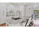 Bright kitchen boasts white cabinetry, marble countertops, stainless steel appliances, and barstool seating at 7133 Dornough Ln, Bradenton, FL 34202
