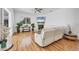 Bright living room with wood floors, a white sofa, ceiling fan, fireplace, and views of the backyard at 7133 Dornough Ln, Bradenton, FL 34202