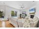 Cozy living room with wood floors, white couches, a fireplace, and a view of the screened-in pool area at 7133 Dornough Ln, Bradenton, FL 34202