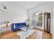 Bright living room with hardwood floors, large window, and stylish blue velvet sofa at 7133 Dornough Ln, Bradenton, FL 34202