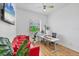 Bright home office featuring a red couch, modern desk, and natural light at 7133 Dornough Ln, Bradenton, FL 34202