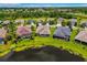 An aerial view shows homes in a suburban neighborhood next to a lake and lush green spaces at 773 Rosemary Cir, Bradenton, FL 34212