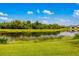 Scenic view of a well-maintained backyard extending to a tranquil lake with abundant greenery at 773 Rosemary Cir, Bradenton, FL 34212