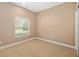 This carpeted bedroom has a neutral color palette and a bright window with wooden blinds at 773 Rosemary Cir, Bradenton, FL 34212