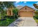A beautifully landscaped property features mature trees and a spacious two-car garage with driveway at 773 Rosemary Cir, Bradenton, FL 34212