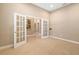 An office with French doors sits off the entry featuring neutral walls and beige carpet at 773 Rosemary Cir, Bradenton, FL 34212