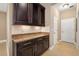 Butler's pantry with rich cabinetry, granite counters, and white tiled backsplash at 773 Rosemary Cir, Bradenton, FL 34212