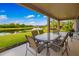 A covered patio offers outdoor dining with relaxing views of the lush backyard and serene lake at 773 Rosemary Cir, Bradenton, FL 34212