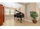 A grand piano sits under a chandelier in a sunlit music room with tile floors at 773 Rosemary Cir, Bradenton, FL 34212