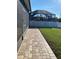 Brick walkway leading to a backyard with an enclosed pool area at 7750 Ridgelake Cir, Bradenton, FL 34203